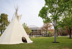 Photo of tip in front of brick buildings on campus