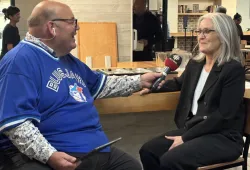 Man holding a microphone while interviewing a woman 