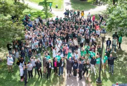 photo of a large group of people standing in the quadrangle cheering