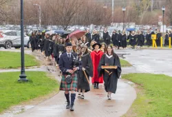 Graduates in the UPEI faculties of Nursing and Veterinary Medicine are led into the Chi-Wan Young Sports Centre for their Convocation ceremony on May 12 by Marshal Dr. Lisa Chilton; Macebearer Dr. Laura Groves, Faculty of Veterinary Medicine; and Eagle Feather Bearer Andrea Gallant, Faculty of Nursing. 