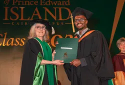image of woman presenting a degree to a graduating student