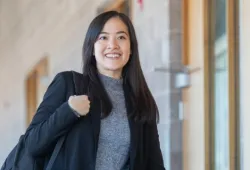a smiling student walking in a hall