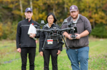researchers look at a drone
