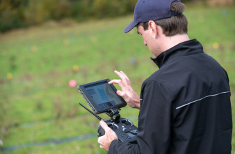 A drone pilot operates a remote control
