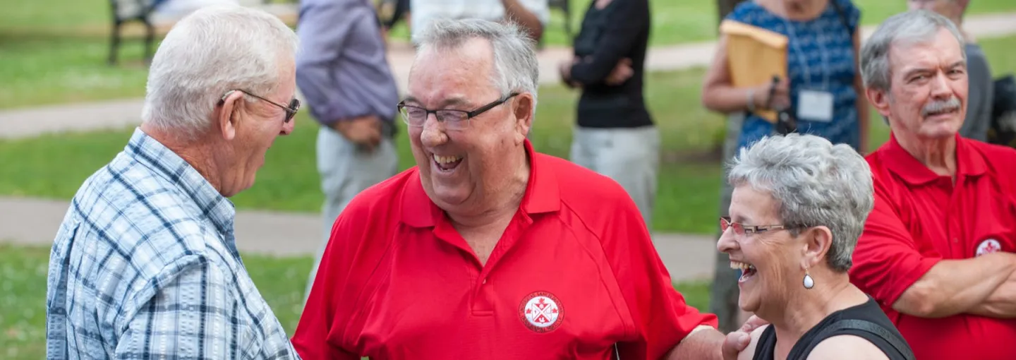 a group of three people laughing in the UPEI quadrangle