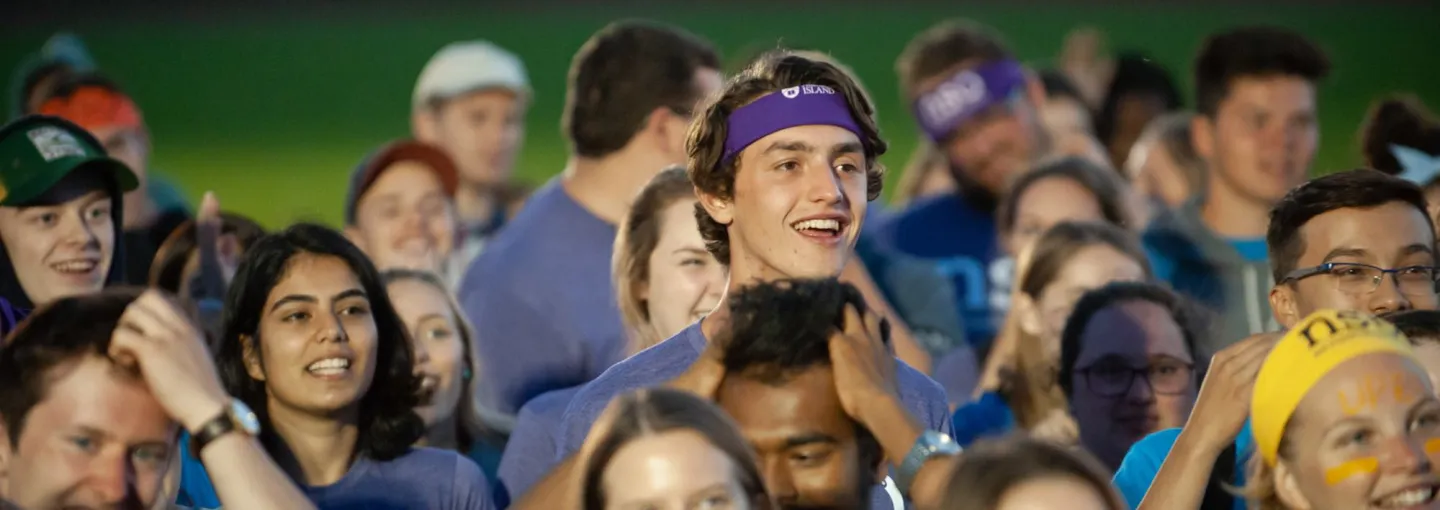 a large group of smiling students at night