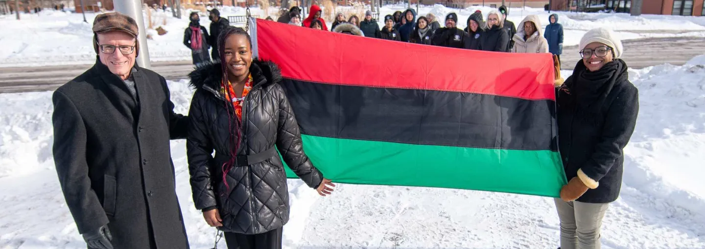 three individuals with the Pan-African flag