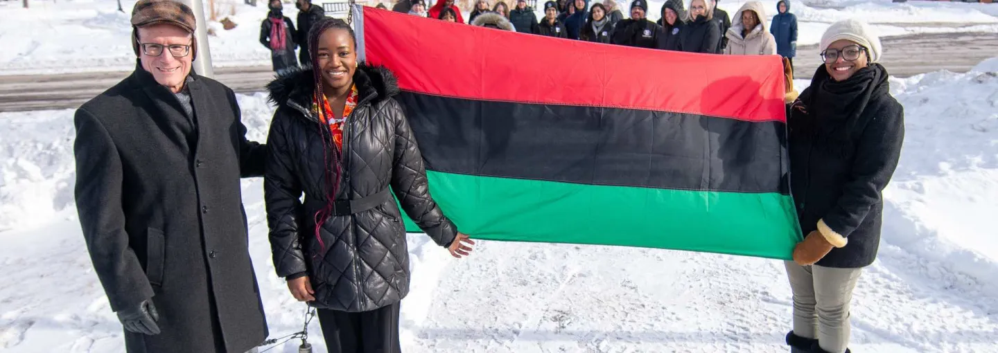 three individuals with the Pan-African flag