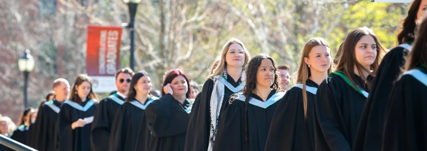 a procession of UPEI graduates in blue hoods