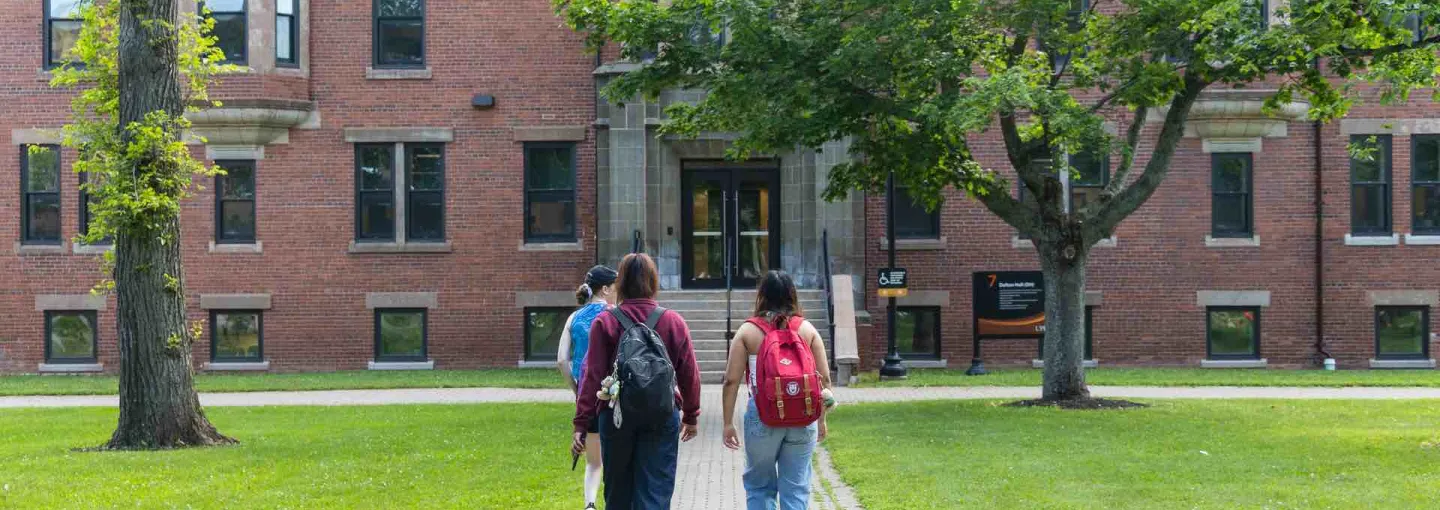 three students walking in the UPEI quad