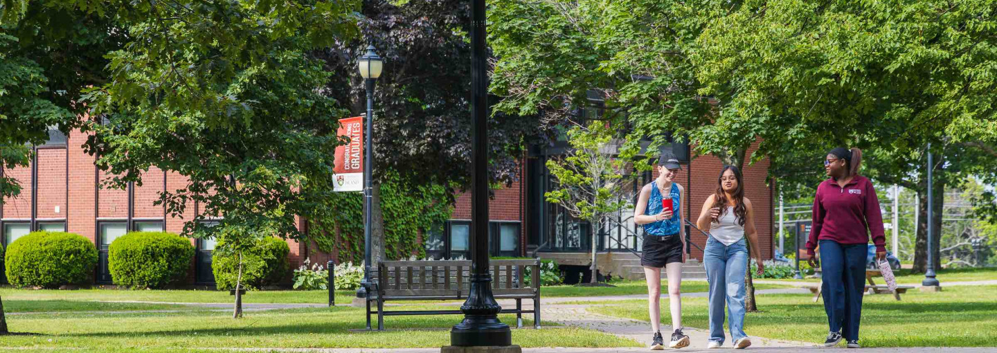 three students walking in the UPEI quad