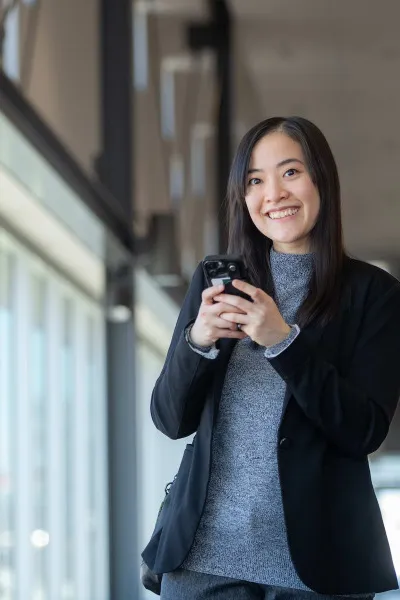 a smiling student using a cell phone