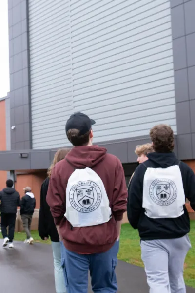 students wearing white UPEI bags walking on campus