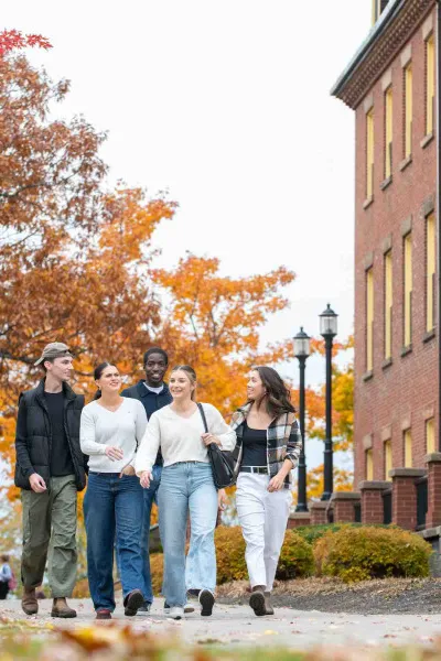 five students in fall walking in front of SDU Main Building