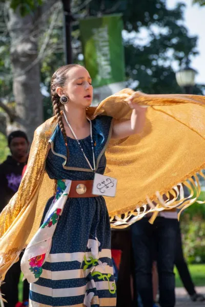 a dancer in orange dress at a commemorative event