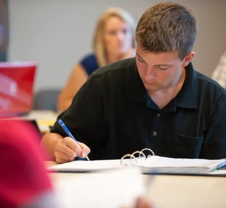 student writing in a notebook