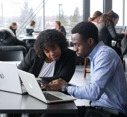 two business students looking at a computer