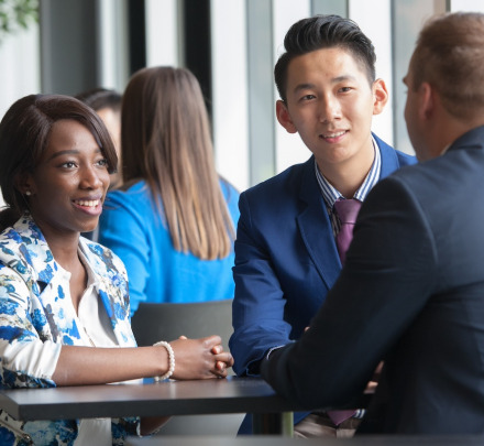 three business students talking at a small table
