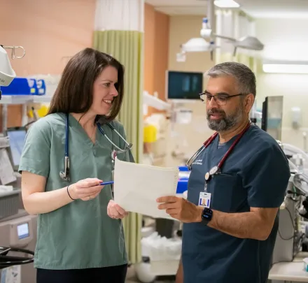 two medical professionals examining a patient chart
