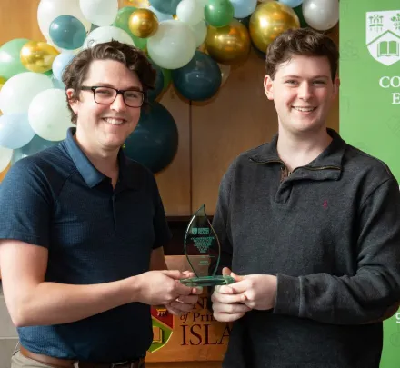 two students holding a crystal award