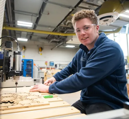 an engineering student wearing safety glasses working on a project