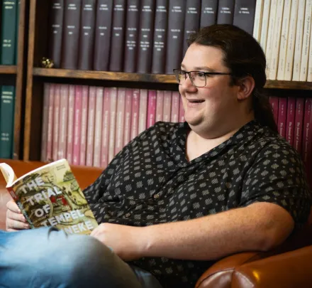 a student reading a book in a student lounge