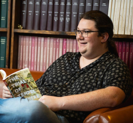 a student reading a book in a student lounge