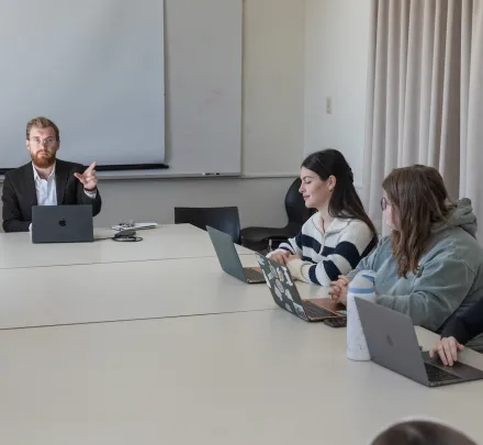 a professor leading a lecture with three students
