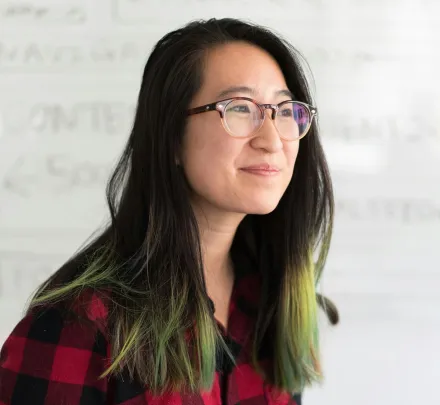 a smiling faculty member in a plaid shirt
