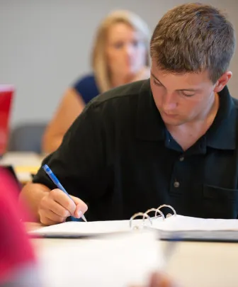 student writing in a notebook