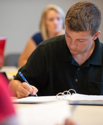 student writing in a notebook