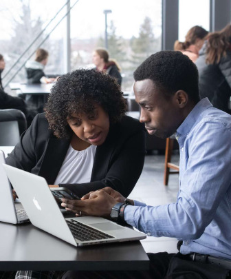 two business students looking at a computer