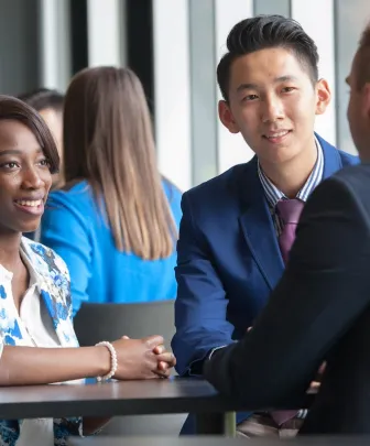 three business students talking at a small table