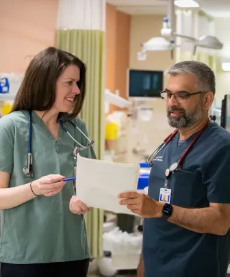 two medical professionals examining a patient chart