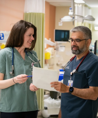 two medical professionals examining a patient chart