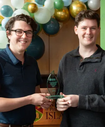 two students holding a crystal award