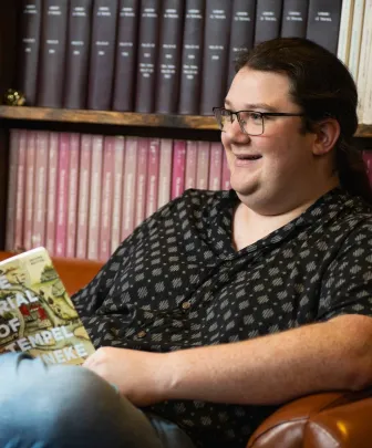 a student reading a book in a student lounge