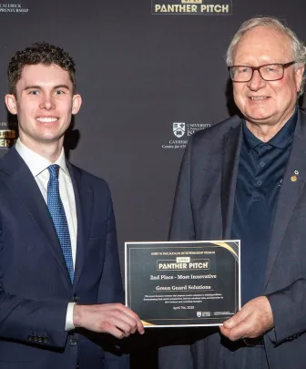 two people holding an award