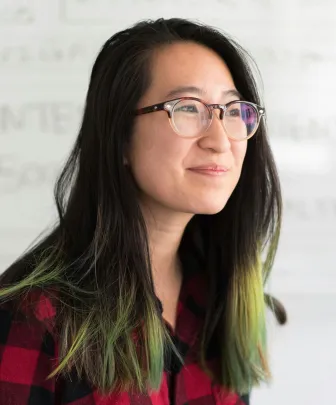 a smiling faculty member in a plaid shirt
