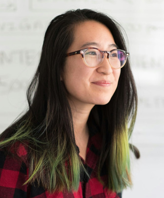 a smiling faculty member in a plaid shirt