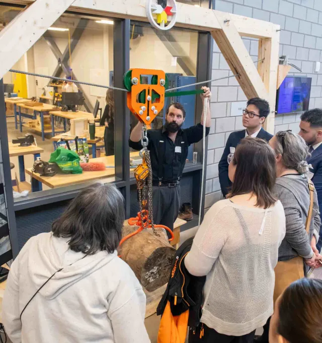 a group watching a demonstration of an engineering student project