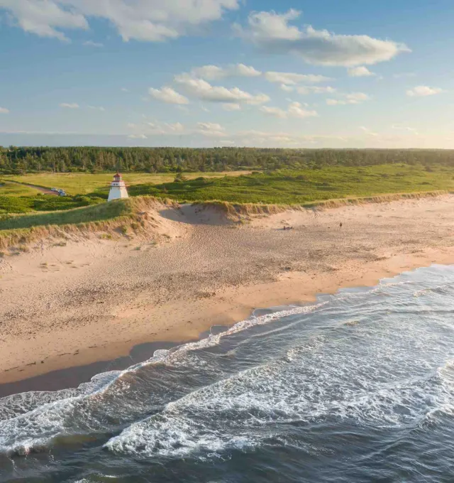 drone image of a PEI shoreline with a lighthouse