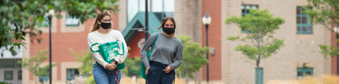 Students walk across campus in face masks 