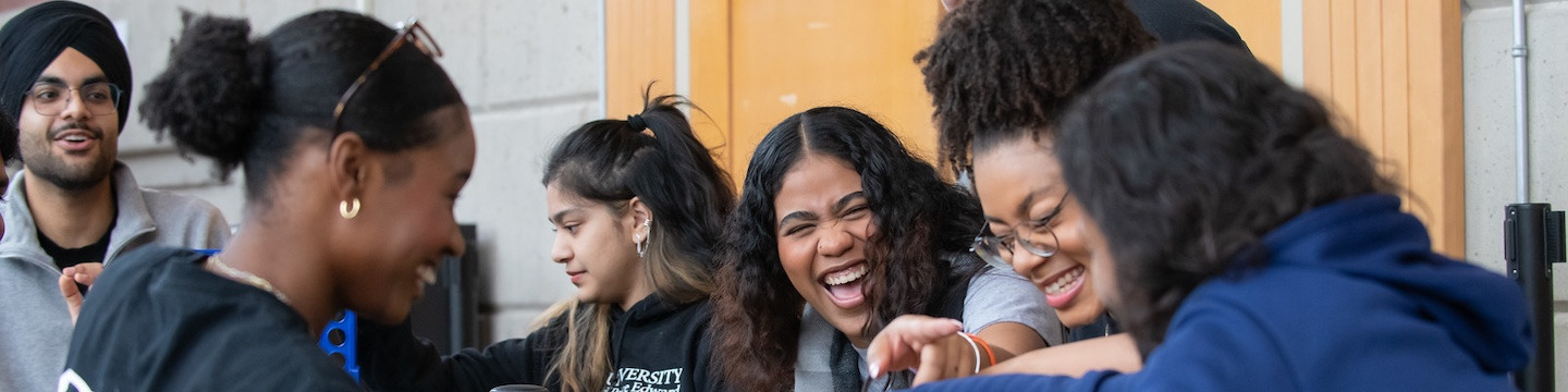 a group of students laughing and playing a board game