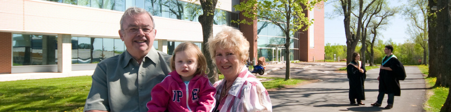 Donors stand with their granddaughter on campus