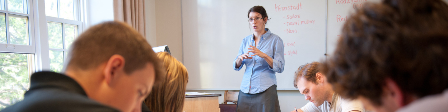 A professor speaks at the front of a classroom