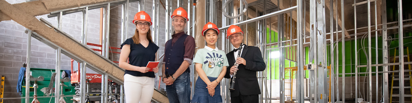 two faculty and two students in the new UPEI performance hall during its construction
