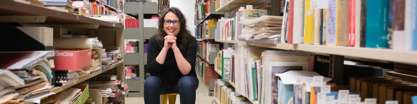 dr. kate scarth sitting between the stacks in upei's robertson library