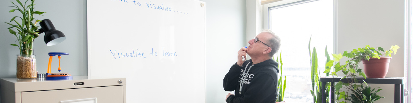 Dr. Derek Lawther reading a whiteboard