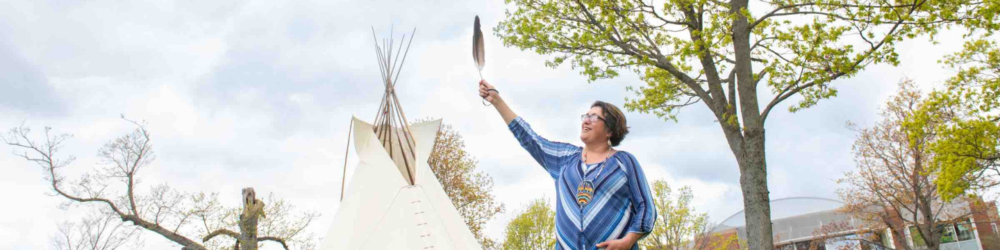 Indigenous language instructor Doris Googoo holding an eagle feather